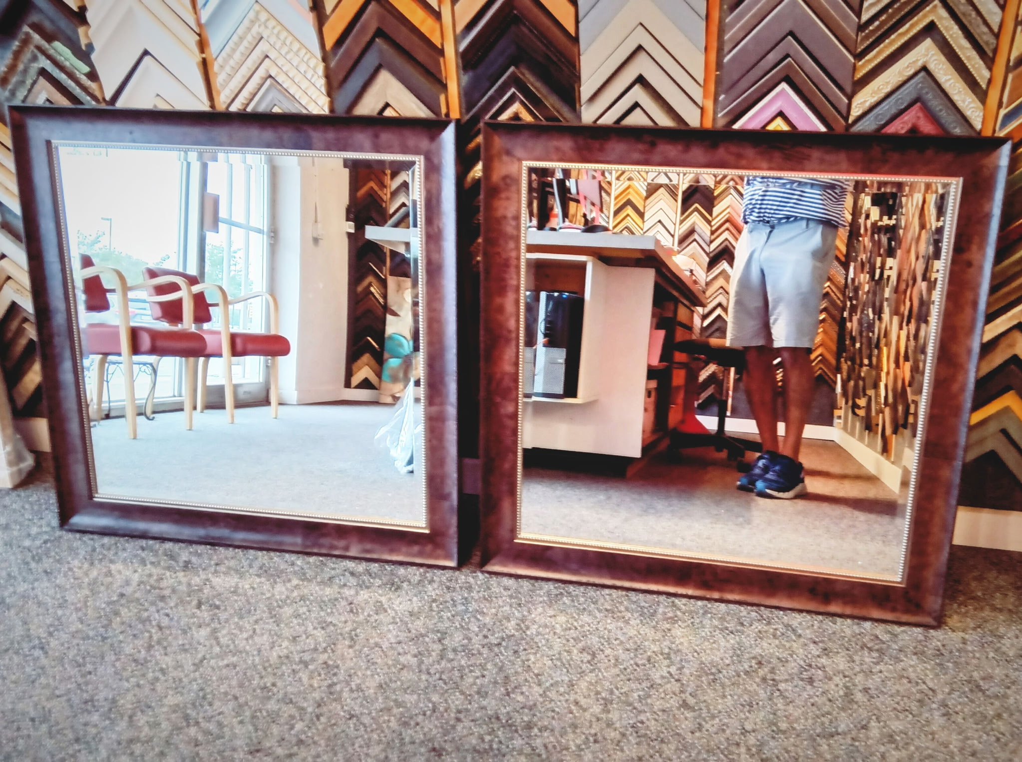 Pair of large dark-wood framed mirrors with a gold fillet, photographed in the shop